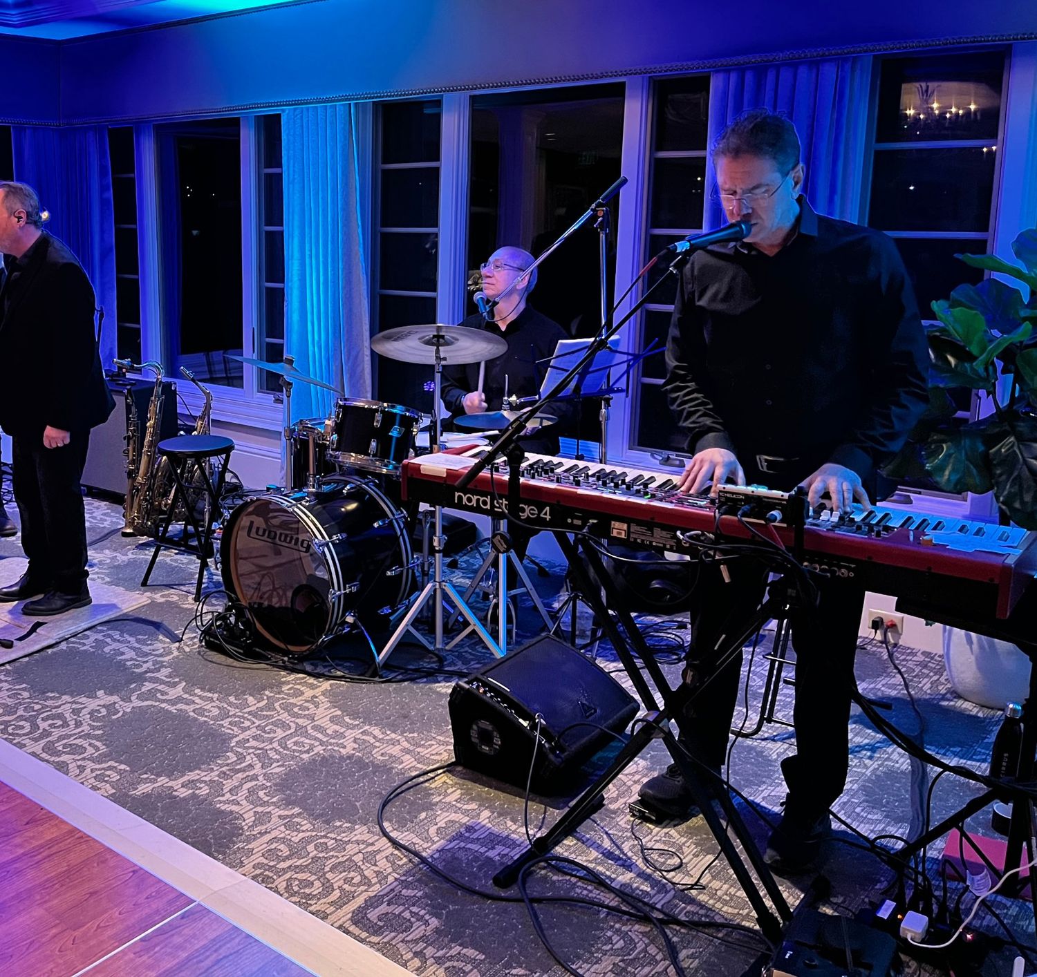Damian Cremision singing, Patrick Martucci on drums and Scott Woska at the Nord Stage keyboard during a show.